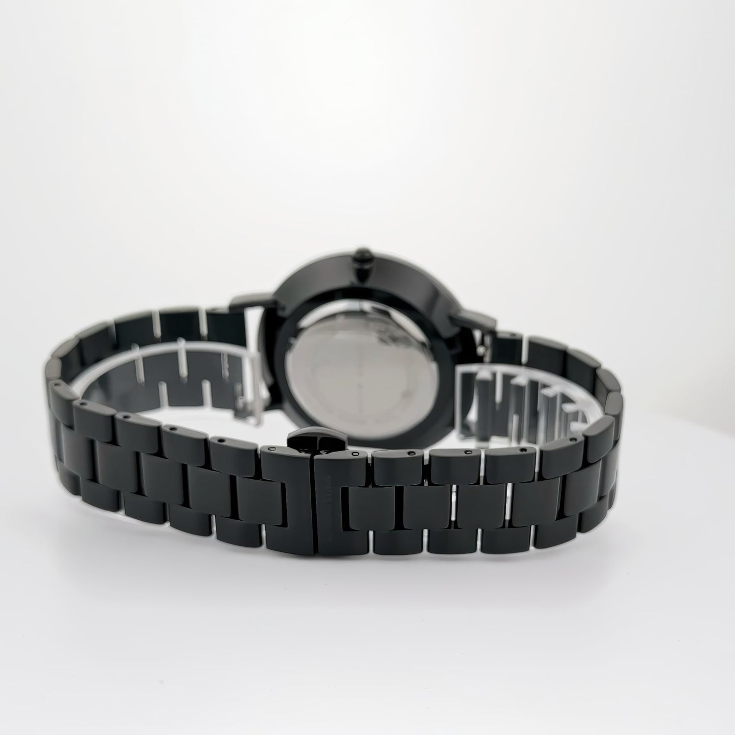 Back view of an Alfred Sung Metropolitan, showcasing its sleek black bracelet and rosegold accents on a white surface.