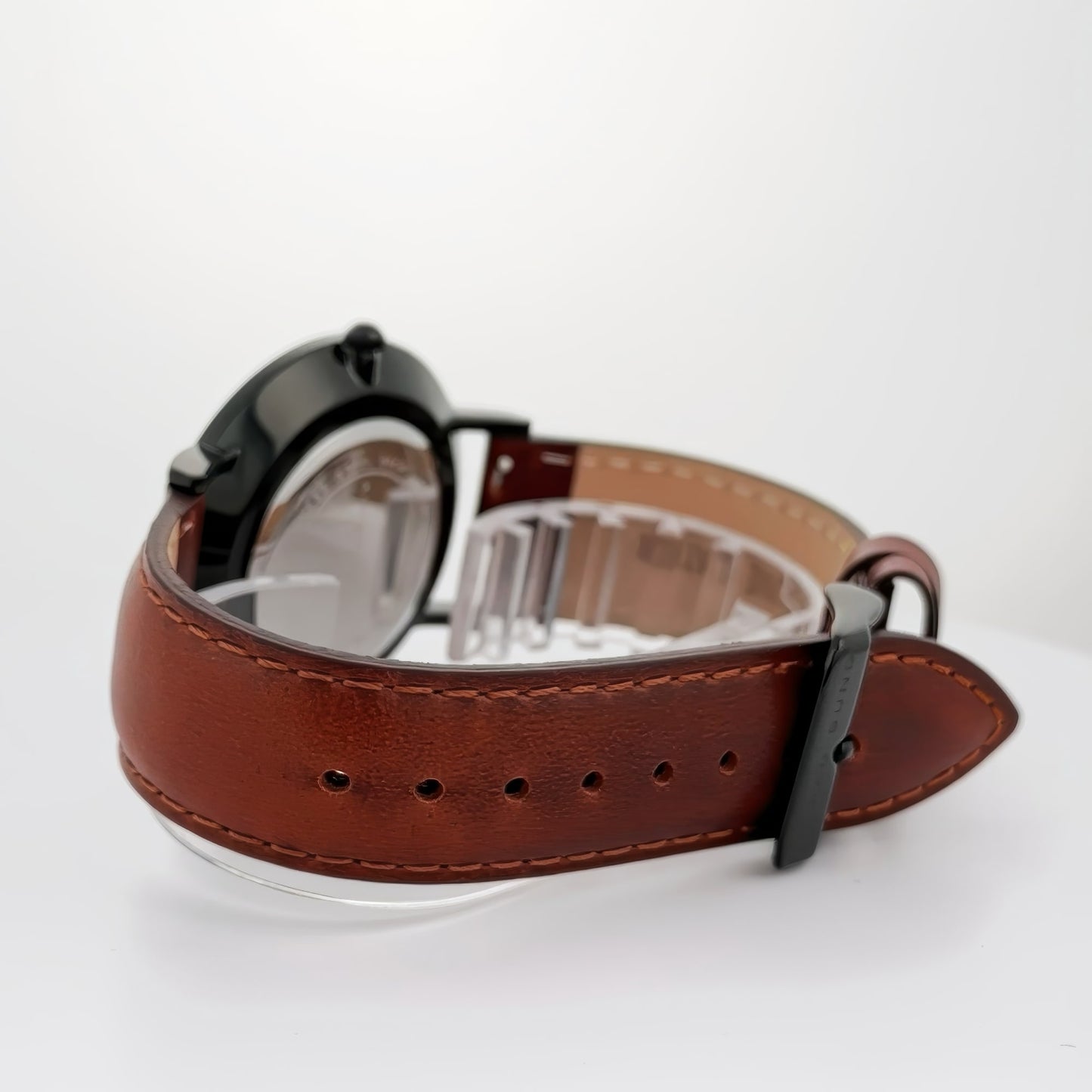 Alfred Sung Metropolitan Date watch featuring a black dial, case, and leather strap on a white surface.