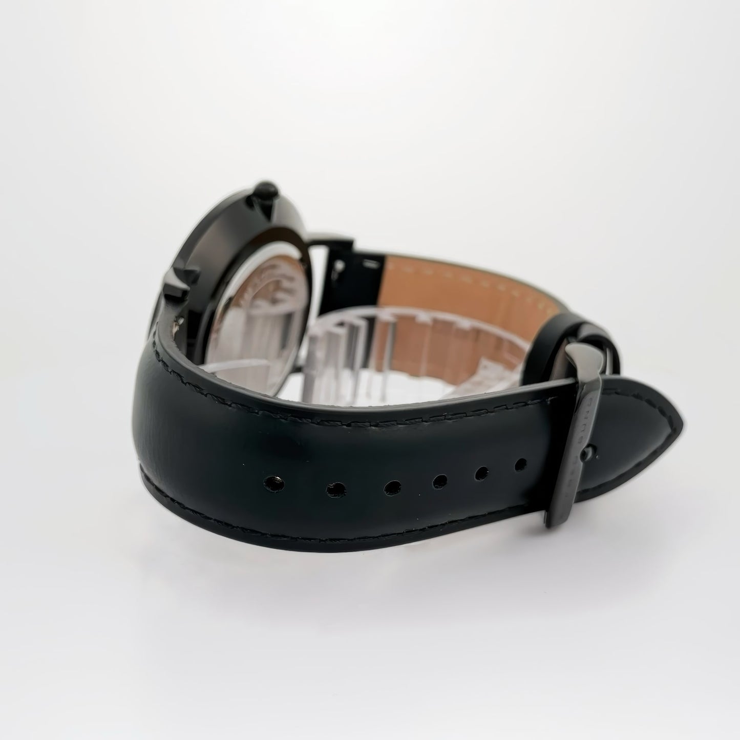 Alfred Sung's Metropolitan watch with a blue dial, silver case, and black leather strap displayed on a white surface.