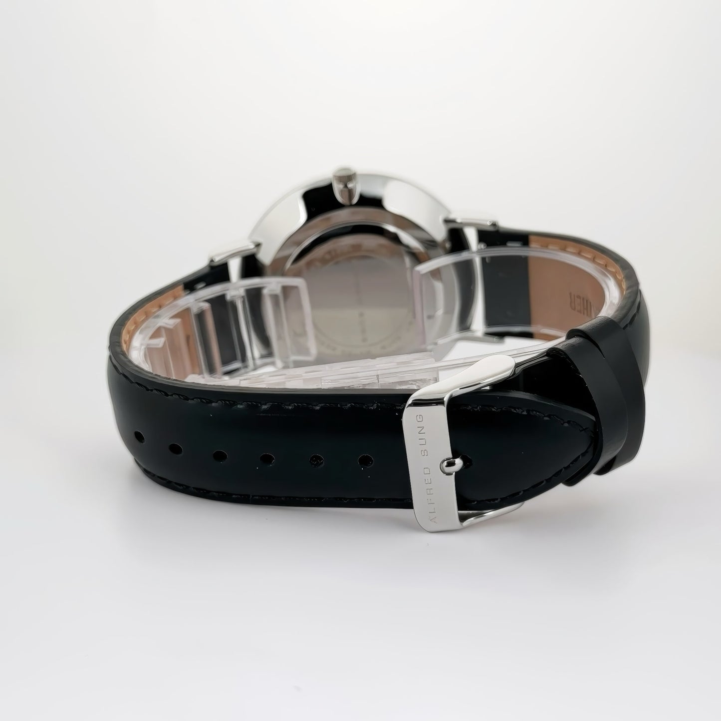 Alfred Sung Metropolitan watch showcased face down, highlighting its Italian leather strap's buckle and stitching.