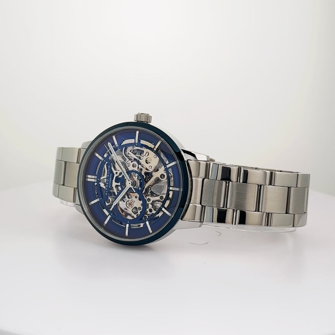 Alfred Sung Automatic III men's watch with blue skeleton dial and silver bracelet, shown on a white surface.