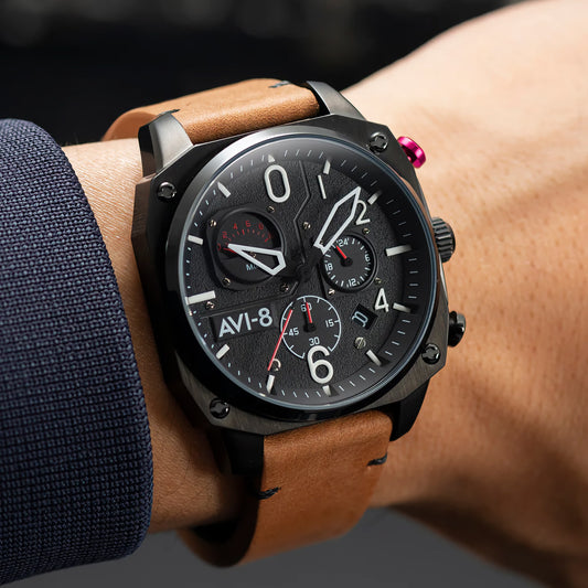 The AVI-8 Hawker Hunter Chronograph with a brown leather strap is worn in a dim setting, displaying the time.