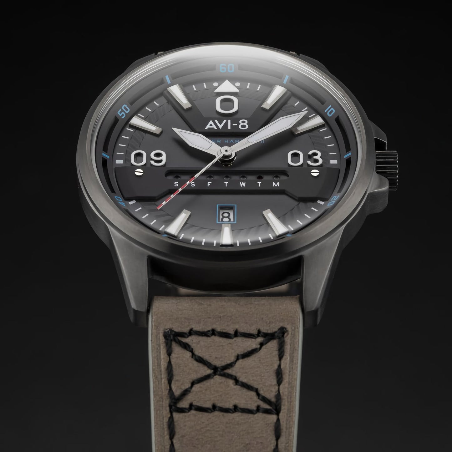 The AVI-8 Hawker Harrier II has a round black dial, brown leather strap, Japanese quartz movement, and day-date display.