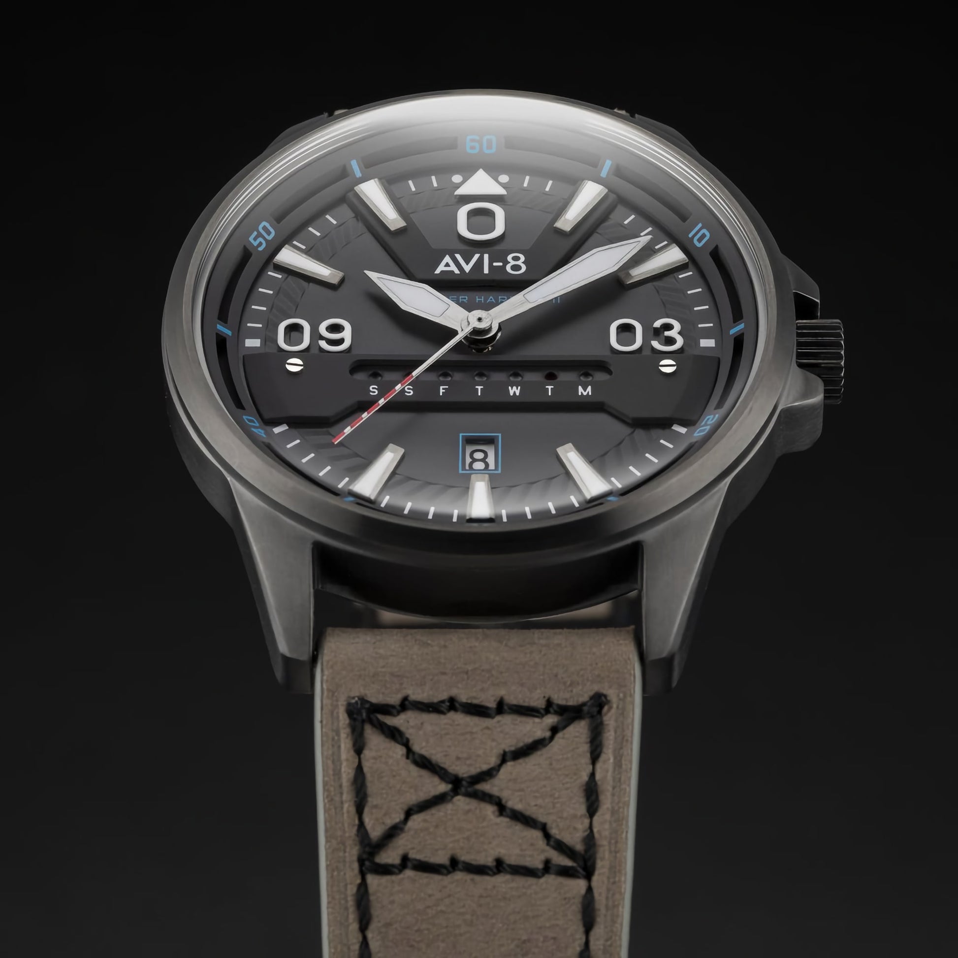 The AVI-8 Hawker Harrier II has a round black dial, brown leather strap, Japanese quartz movement, and day-date display.