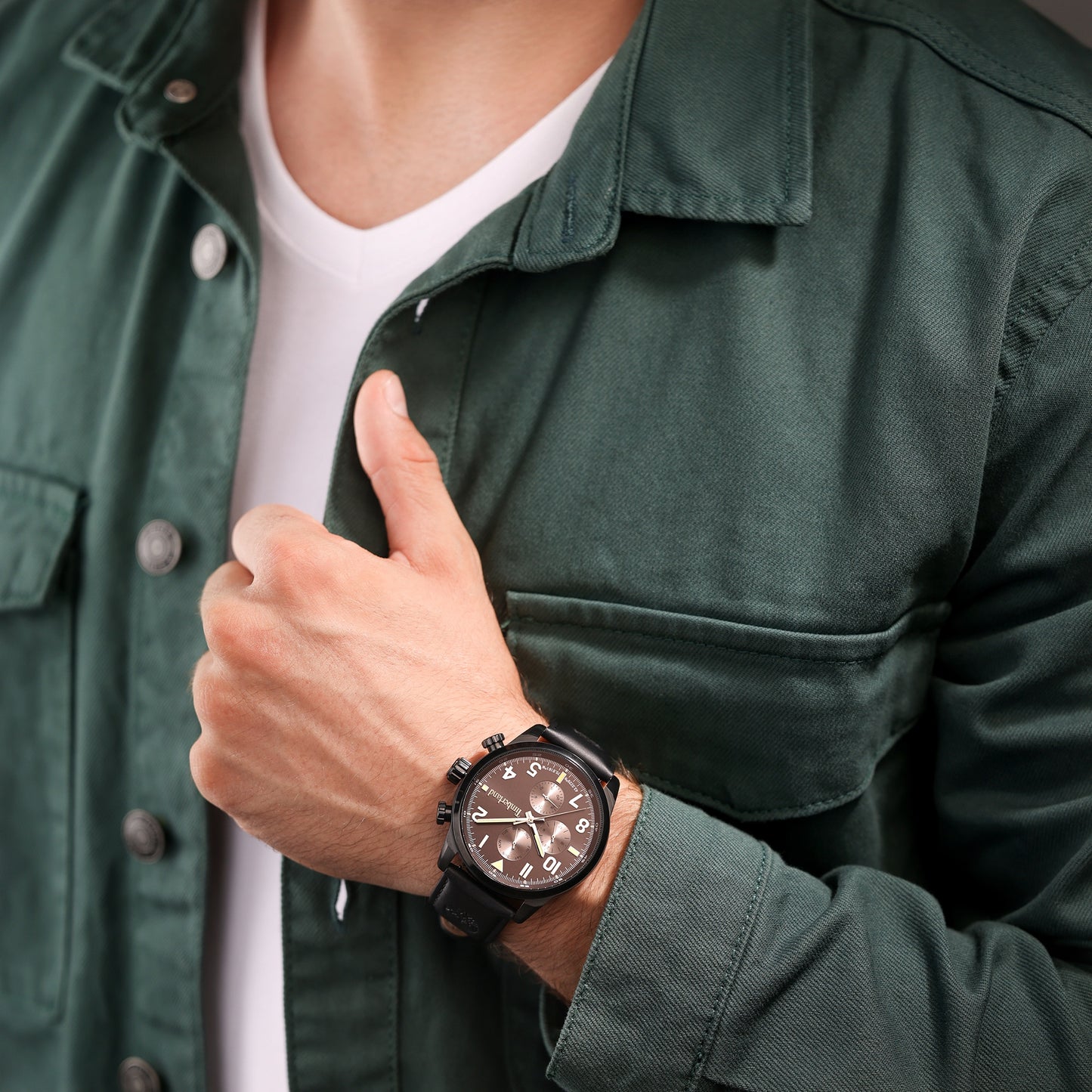 Man in green jacket giving thumbs up, wearing a Timberland Henniker leather strap watch.