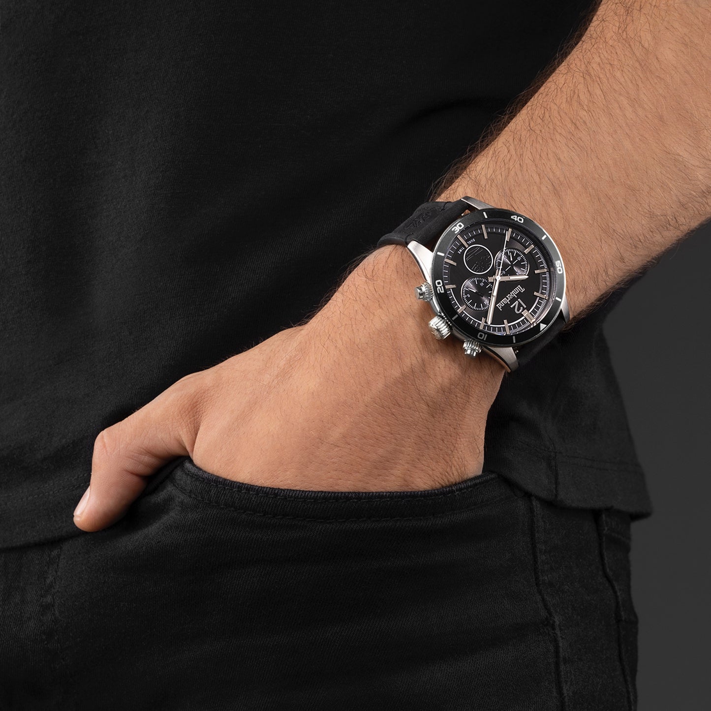 A Timberland Ashmont men's chronograph with a leather strap is worn, hand in pocket, against a dark background.