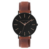 The Alfred Sung Metropolitan watch has a black dial, gold details, and an Italian leather strap.