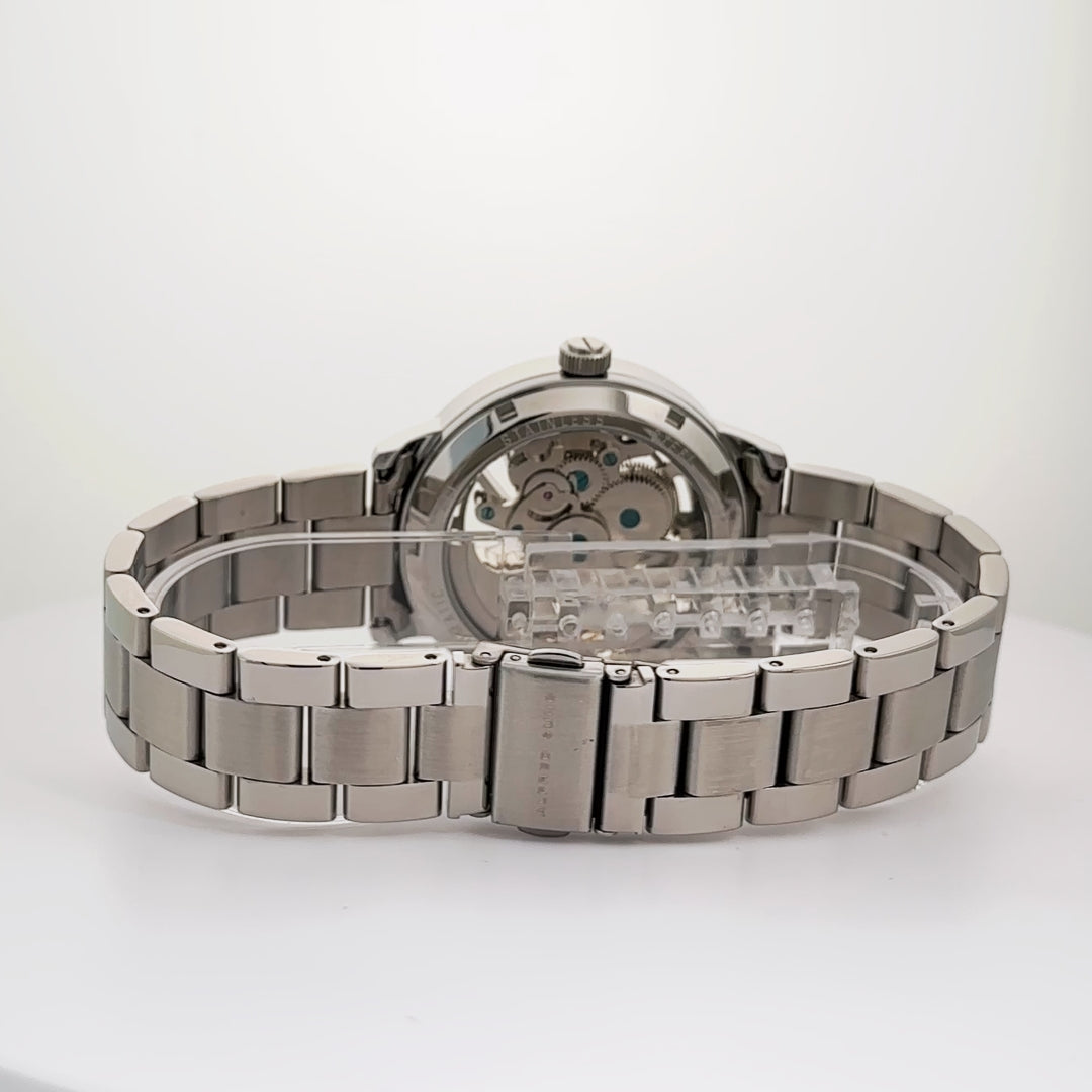 Alfred Sung Automatic III men's watch with blue skeleton dial, silver bracelet, and transparent case back.