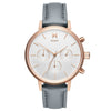 MVMT Nova Dorado watch: white face, three subdials, gold markers, gray leather strap.
